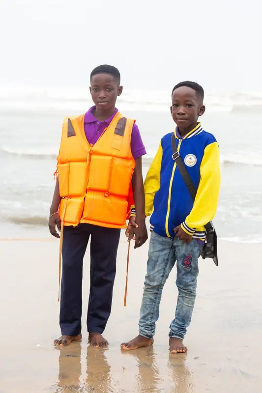 Two pupils in life jackets on the wet sand