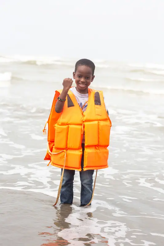 A young pupil in a life jacket in the shallows