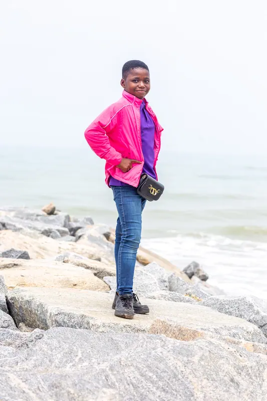 A pupil standing on the rocky sea defence
