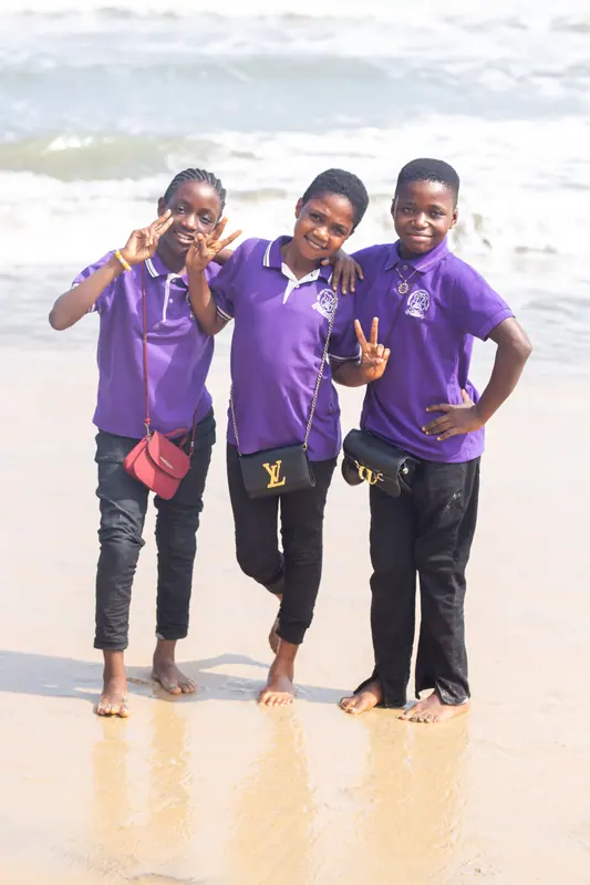 Three pupils posing together on the beach