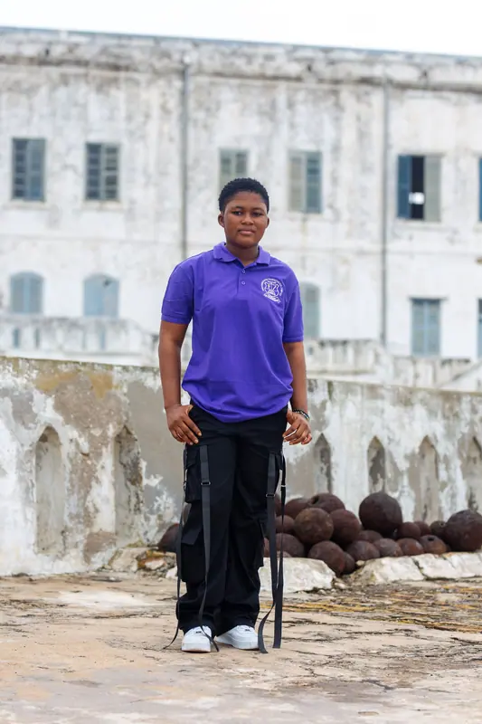 A pupil beside the cannonballs at the castle wall