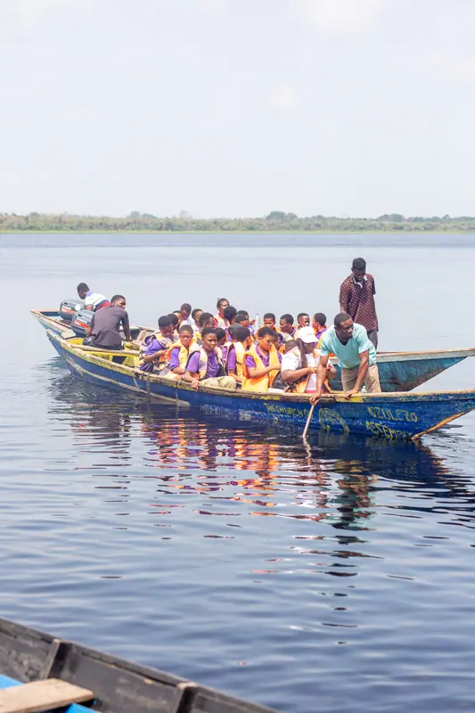 A canoe carrying pupils across the lake to the stilt village
