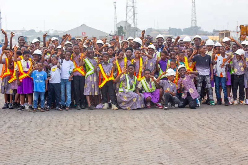The whole excursion party photographed together, hands raised