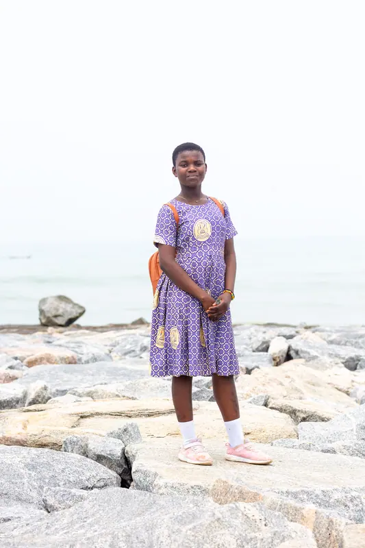 A pupil standing on the rocky shoreline