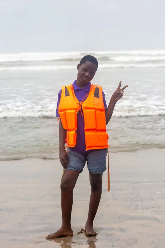 A pupil in a life jacket on the beach