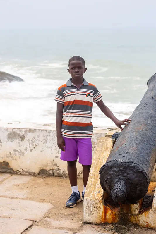 A pupil beside a cannon on the castle ramparts