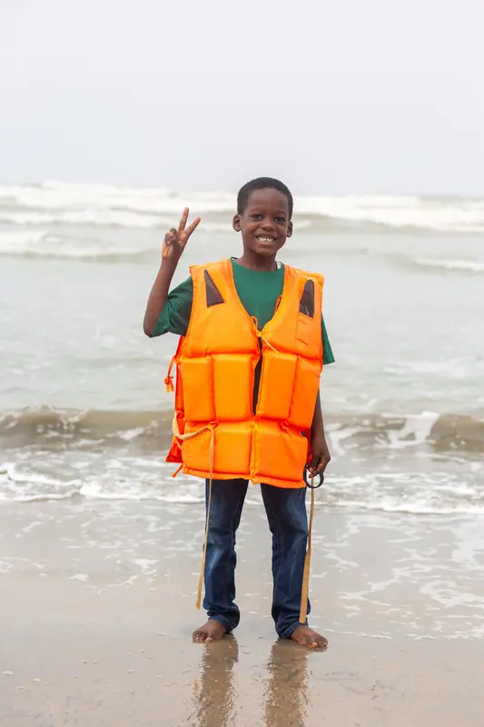 A pupil in a life jacket in the surf