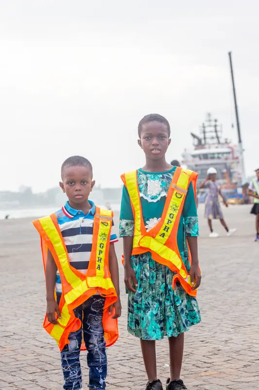 Two pupils in high-visibility vests on the harbour promenade