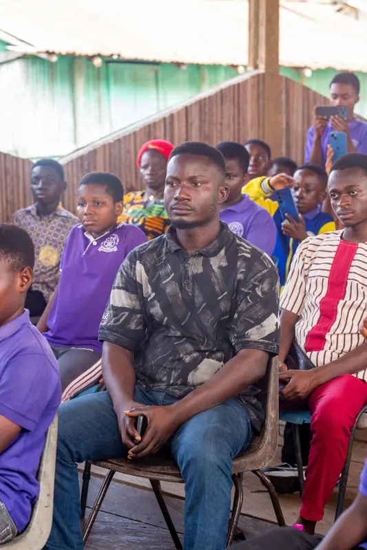 Pupils and staff seated together at the stilt village