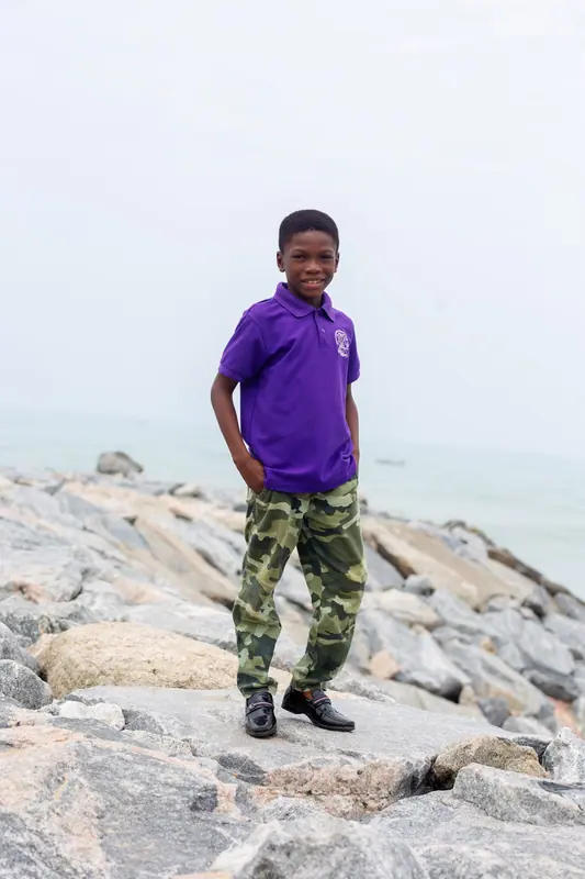 A pupil standing on the rocky sea defence