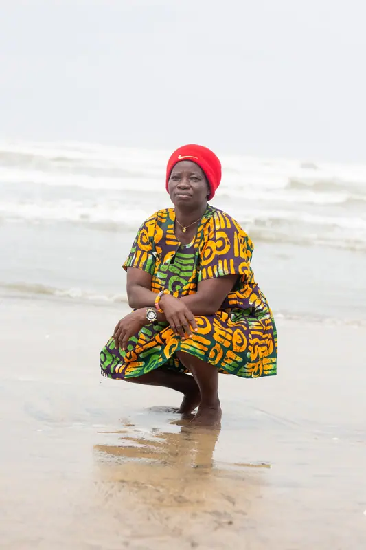 A member of staff in traditional print beside the water