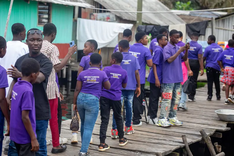 Pupils walking the timber walkway through the stilt village