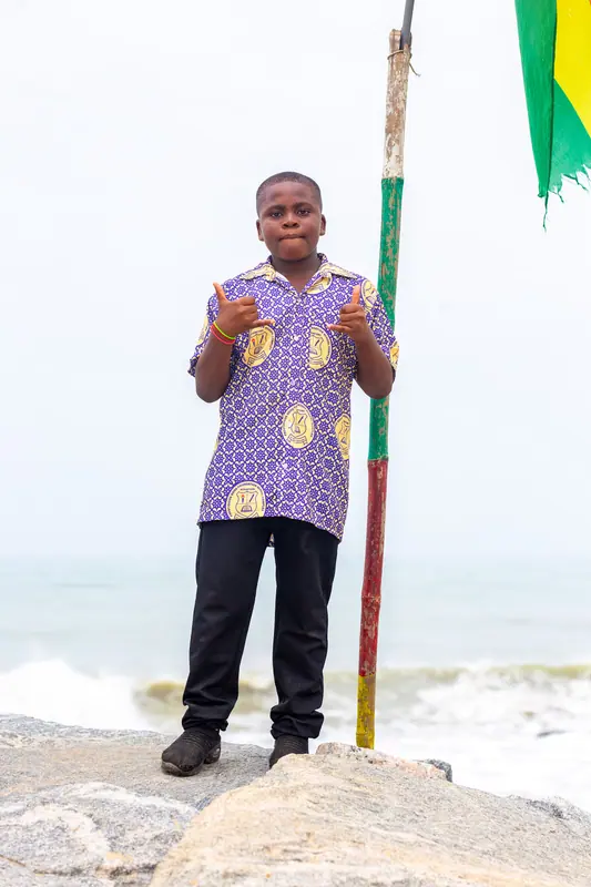 A pupil on the rocks beside a flagpole