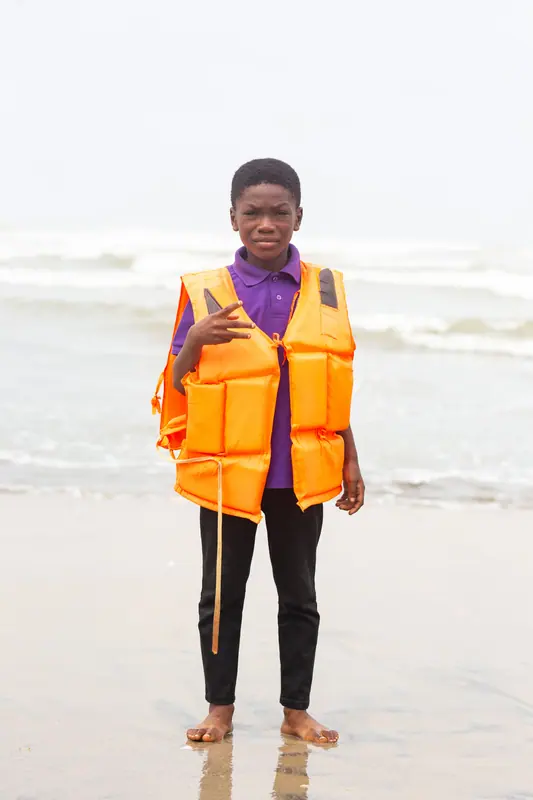 A pupil in a life jacket on the beach