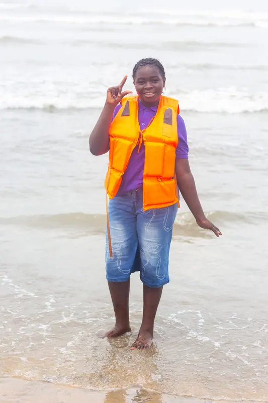 A pupil in a life jacket in the surf