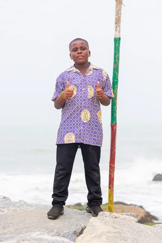 A pupil beside a flagpole at the shore