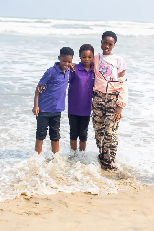 Three pupils standing in the surf