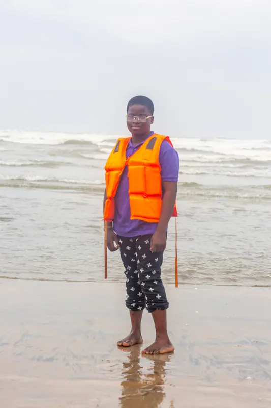A pupil in a life jacket in the shallows