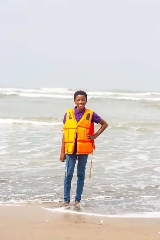 A pupil in a life jacket in the shallows